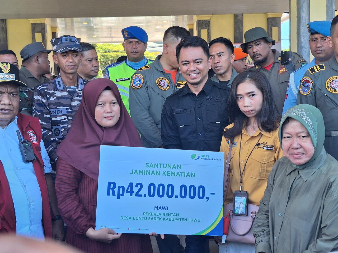 SANTUNAN -- Menteri Sosial, Tri Rismaharini menyerahkan santunan Jaminan Kematian BPJS Ketenagakerjaan kepada ahli waris salah seorang korban banjir dan longsor di Kabupaten Luwu yang merupakan pekerja dan terdaftar sebagai peserta BPJS Ketenagakerjaan.