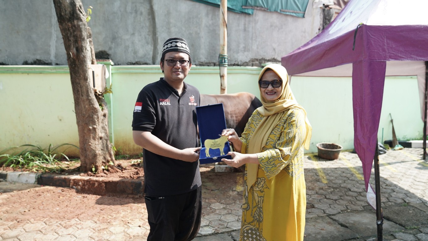 KURBAN MTXL -- Presiden Direktur & CEO XL Axiata, Dian Siswarini (kanan) menyerahkan secara langsung hewan kurban miliknya kepada Ketua DKM Musallah An-Nur Syafa'at, Achmad Ekawinardi (kiri), pada Senin (17/6).