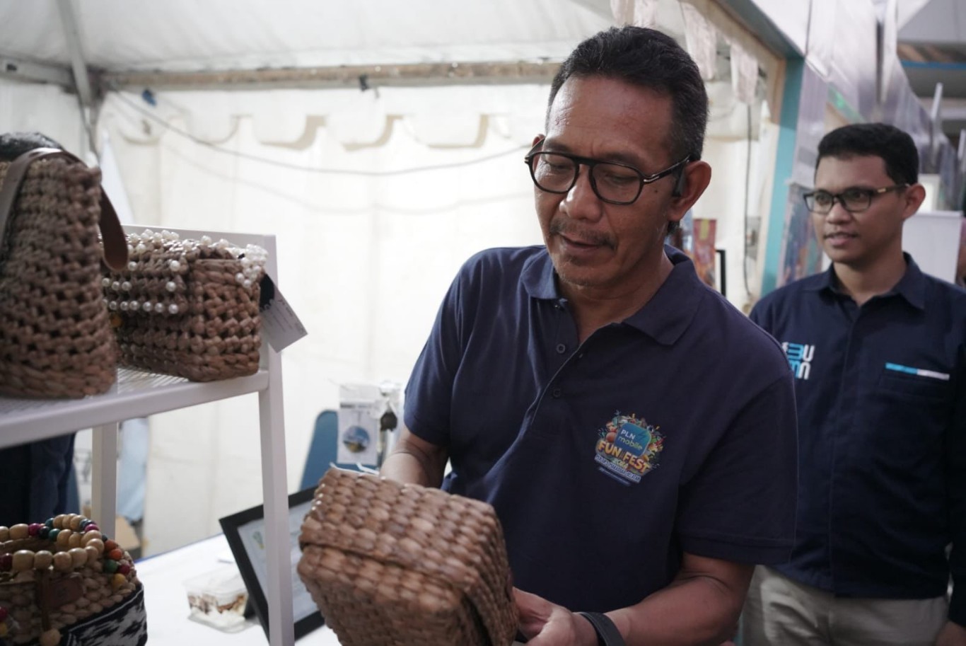 PRODUK UMKM -- General Manager PLN UID Sulselrabar, Moch. Andy Adchaminoerdin melihat produk UMKM Rumah BUMN PLN di PLN Mobile Fun Fest 2024. 
