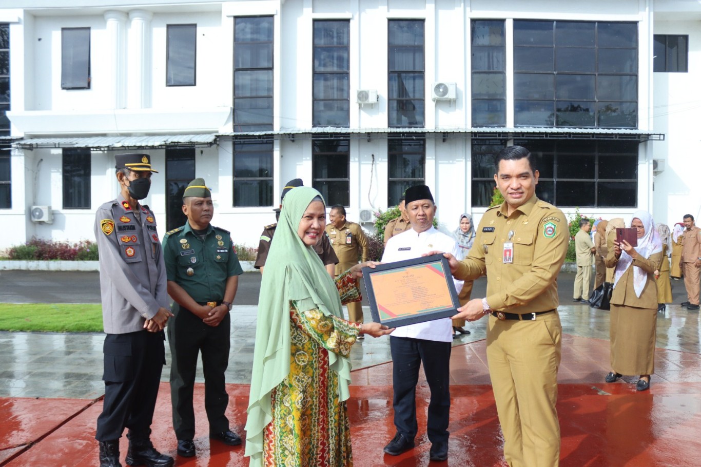 PURNA BAKTI -- Sekkab Takalar, H Muh Hasbi menyerahkan piagam Purna Bakti dari Pemerintah Kabupaten Takalar kepada Hj Hijrah sebagai kepala Bagian Umum Setda Kabupaten Takalar