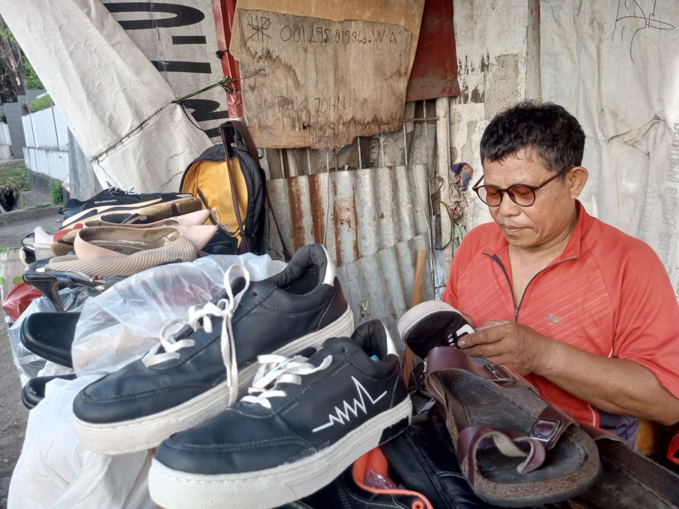 bkm/fajar SEMANGAT--Joni Pasuang tetap bersemangat memainkan jarinya menjahit sepatu dan sandal milik pelanggan. Kini usahanya terus maju hingga mampu menyekolahkan anak hingga selesai dan menafkahi keluarganya.
