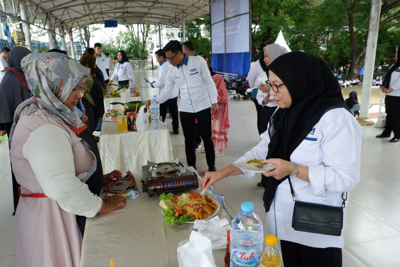 LOMBA MASAK -- Pemimpin Cabang PNM Makassar, Maimun Bakri sedang mencicipi hasil masakan salah seorang peserta lomba masak bertajuk 'Lomba Ultra Mikro Chef' di acara HUT PNM ke-25.