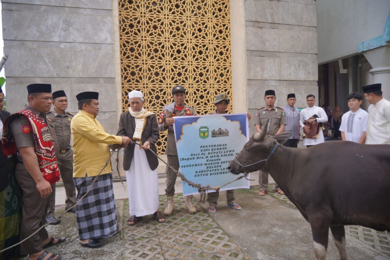 KURBAN -- Pj Bupati Luwu Muh Saleh menyerahkan hewan kurban kepada PHBI untuk disembelih. PHBI melaporkan dua kecamatan yakni Kecamatan Belopa dan Belopa Utara melakukan penyembelihan hewan qurban berjumlah 300 ekor sapi dan 24 ekor kambing.