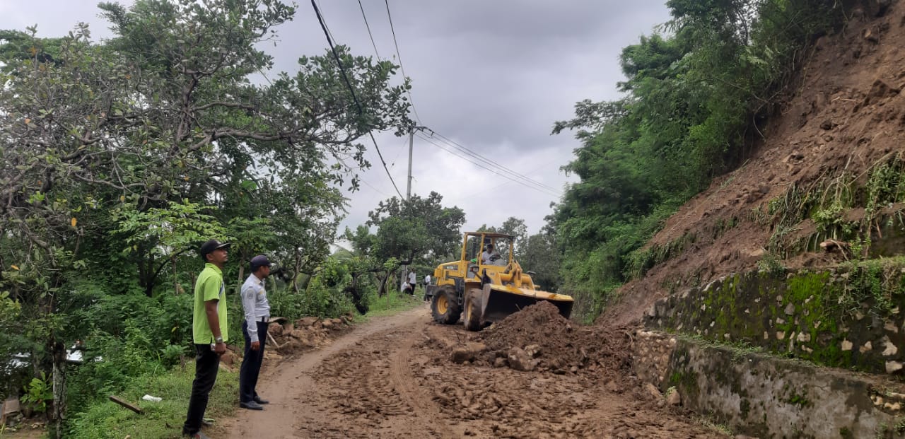 BERSIHKAN -- Pembersihan material longsor dijalan KH Ahmad Dahlan Kabupaten Sinjai dengan menggunakan alat berat dari Dinas PUPR Sinjai dibantu personel Satpol PP,  BPBD, Dishub Sinjai dan warga setempat, Rabu (5/6) pagi.