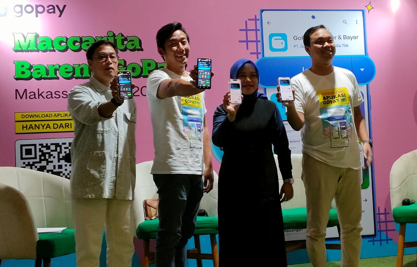 APLIKASI -- Irwan Ari Wibowo, Senior Brand and Marketing Manager GoPay, Pipit, ibu rumahtangga dan konten kreator (dua dari kanan), Yondi Hartanto, Corporate Affairs Lead GoTo Financial (dua dari kiri), menunjukkan aplikasi GoPay dari layar gawainya masing-masing.