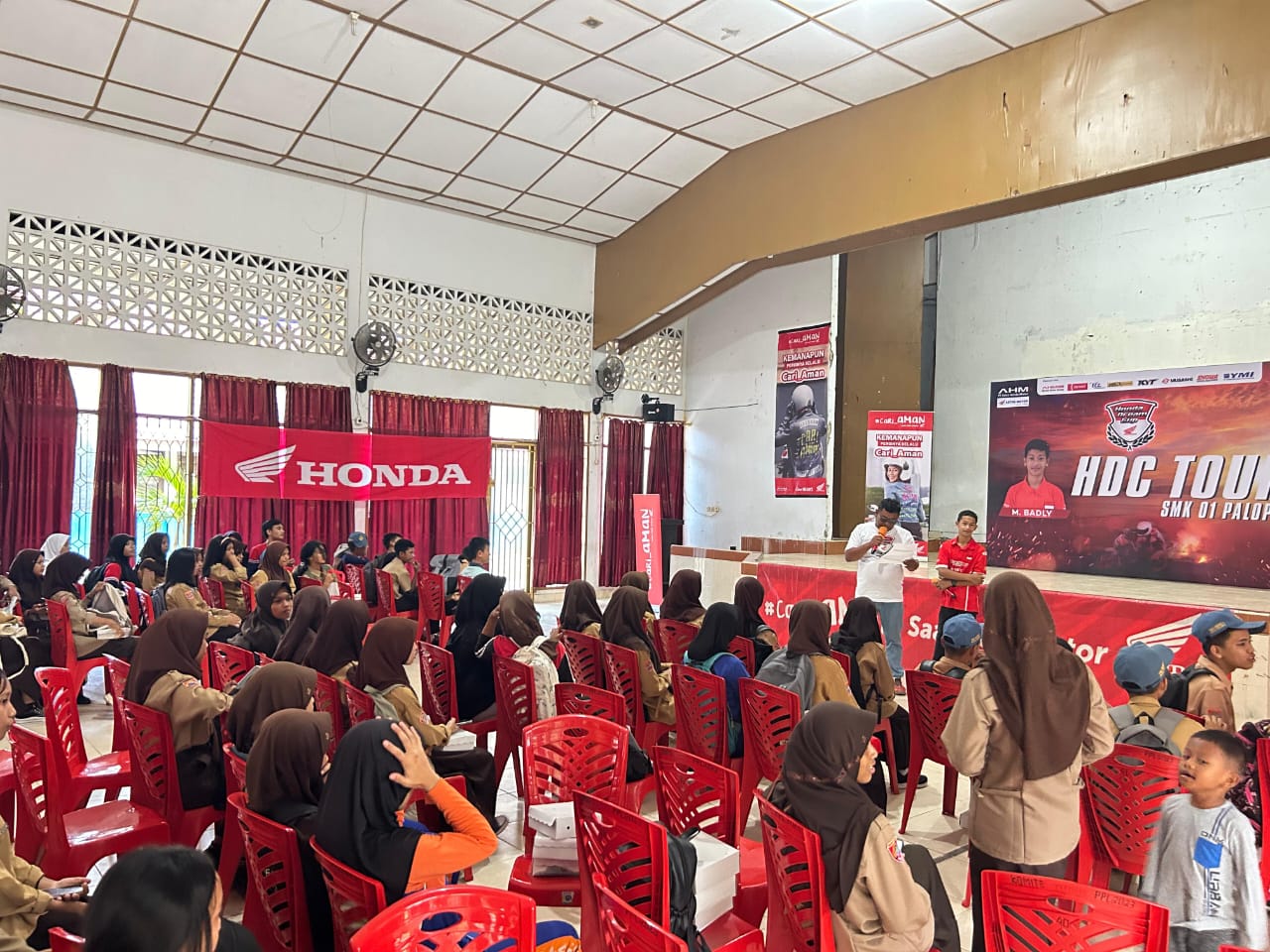 ANTUSIAS -- Para siswa siswi SMKN 1 Palopo tampak begitu antusias mendengarkan cerita pebalap asal tim Honda 86, Ristan M Badly Ayatullah (baju merah) yang berbagi pengalaman terkait membangun karier di dunia balap.