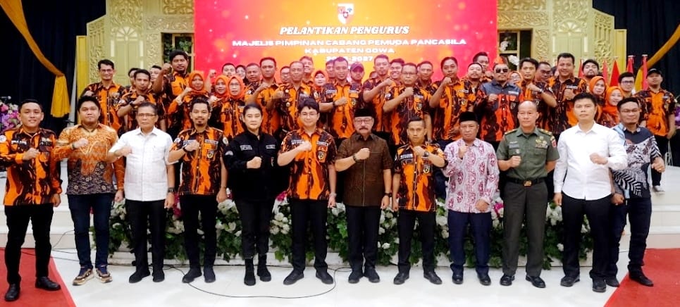 IST LANTIK -- Ketua MPC PP Gowa, Ardiansyah (tengah), mengibarkan panji kebesaran Pemuda Pancasila usai dilantik Ketua MPW PP Sulsel, Diza Rasyid Ali. 
