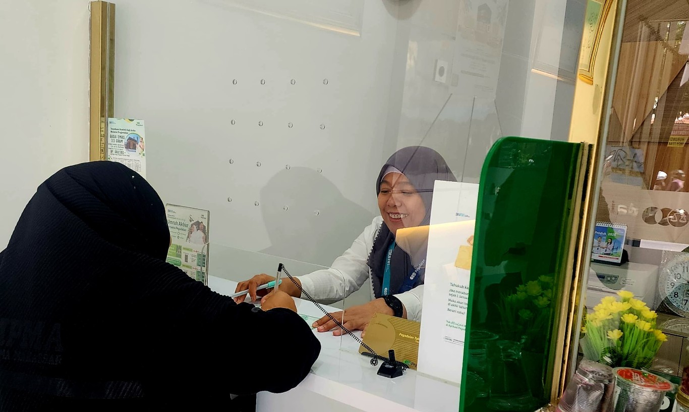 PELAYANAN -- Costumer Service Pegadaian sedang memberikan pelayanan kepada nasabahnya.