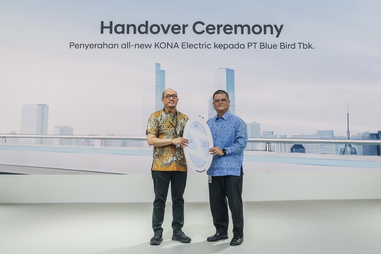 PENYERAHAN -- Moch. Diky Zulkarnaen, Chief Sales Officer Hyundai Motors Indonesia (kiri) menyerahkan secara simbolik All-New KONA Electric dari Hyundai kepada Bluebird yang diterima Coody Johasman Madjid, Commercial Services Director  Pt. Blue Bird Tbk.