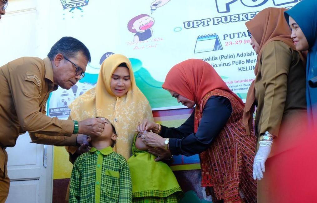 IST VAKSIN -- Pj Sekretaris Kabupaten Gowa, Abdul Karim Dania bersama Wakil Ketua TP PKK Gowa, Mussadiyah Rauf, meneteskan vaksin imunisasi polio kepada sejumlah anak TK. 