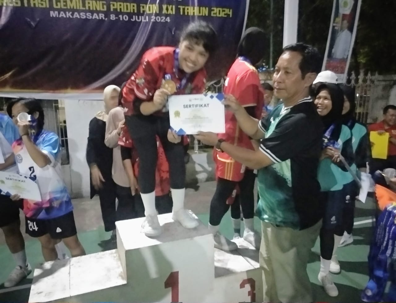 JUARA UMUM -- Salah seorang pemain saat menunjukan medali emas dan piagam usai pengalungan medali dari panitia Kejurda di Lapangan Sepaktakraw GOR Gedung Mulo Kantor Dinas Pariwisata Sulsel, Rabu (10/7) malam. Kontingen Pinrang keluar sebagai juara umum dengan satu medali emas dan dua medali perunggu. 
