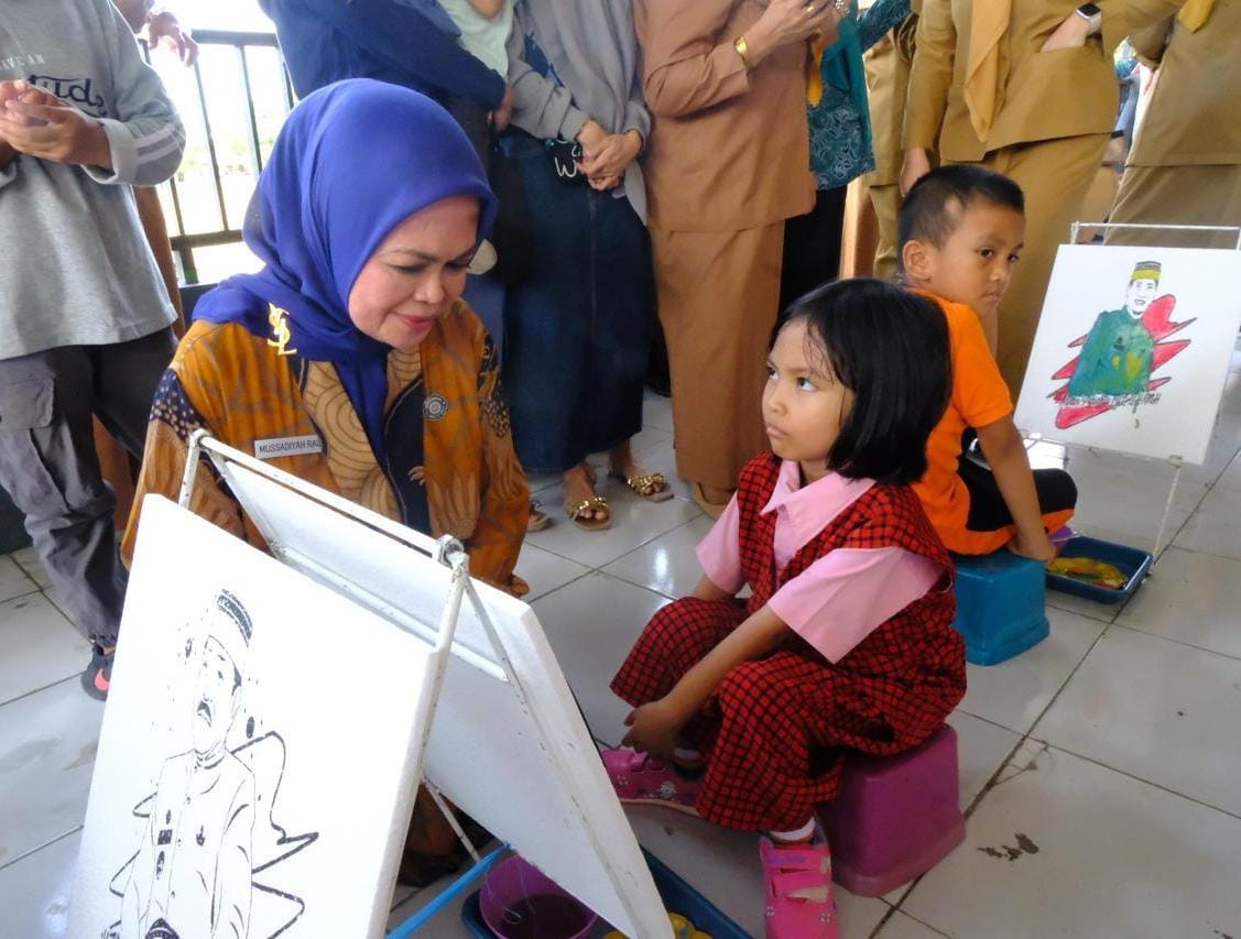 IST ANAK -- Wakil Ketua TP PKK Gowa, Mussadiyah Rauf, mencoba mengakrabi seorang anak yang bermain di Posyandu di Moncobalang. 