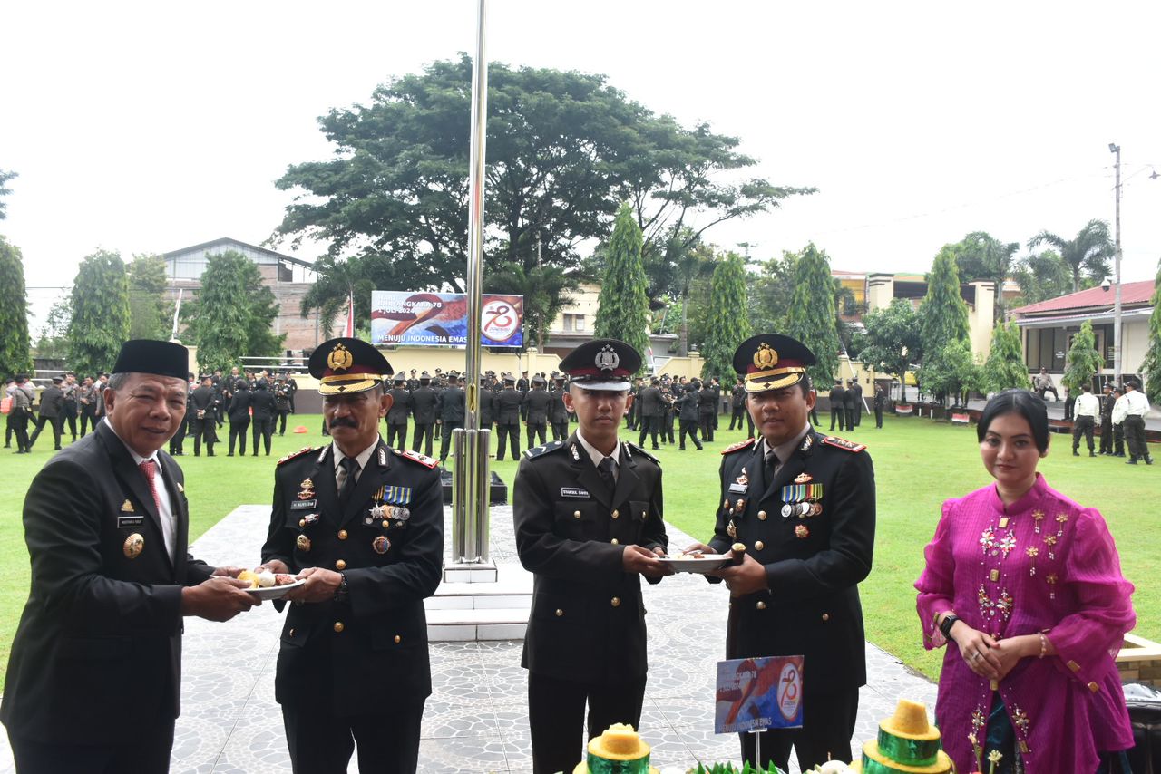 TUMPENG -- Bupati Bulukumba Andi Muchtar Ali Yusuf bersama Kapolres memotong nasi tumpeng kemudian diberikan kepada personel tertua (senior) yakni Kompol H Nuryadin dan personel termuda (junior) Bripda Syamsul Bahri usai upacara HUT Bhayangkara di Mako Polres Bulukumba, Senin (1/7).  