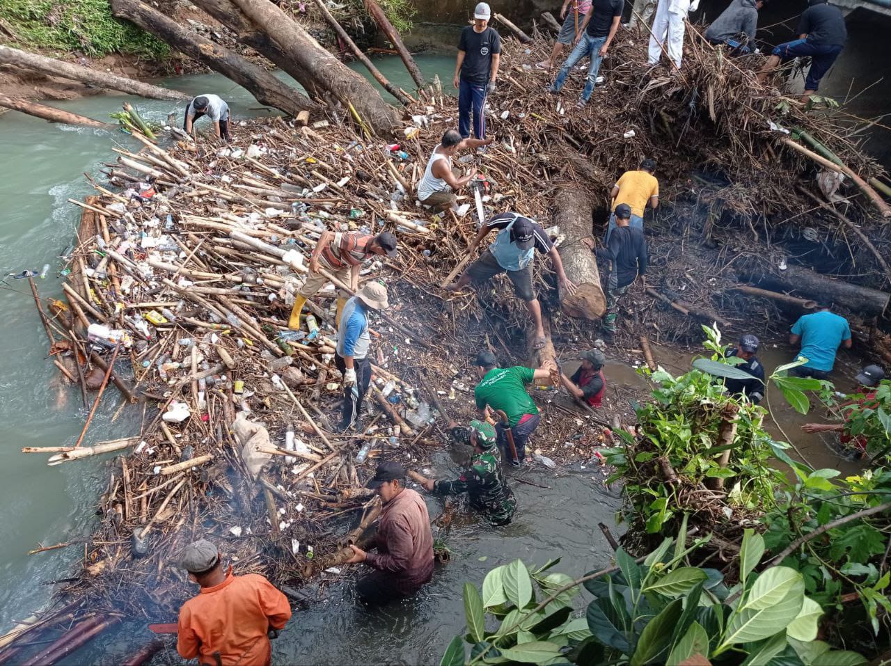 KARYA BAKTI -- Sampah sisa material banjir di Kolong Jembatan Keppe yang menumpuk dibersihkan oleh personel Koramil 1403-01/Larompong melalui Karya Bakti TNI, Rabu (10/7)  