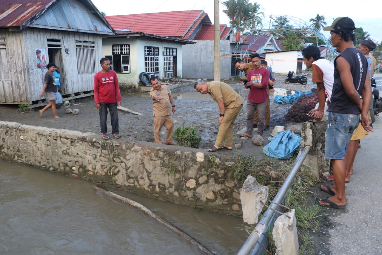 TINJAU -- Bupati Luwu Timur, H Budiman meninjau lokasi bencana banjir di Kecamatan Burau, Selasa (16/7). Peninjauan ini merupakan respons cepat pemerintah daerah terhadap bencana alam yang menimpa masyarakat.