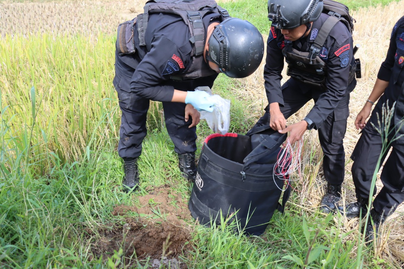 MUSNAHKAN -- Tim Jihandak Brimob Polda Sulsel saat memusnahkan granat yang ditemukan warga Rembon saat membersihkan sawah, Sabtu (6/7).