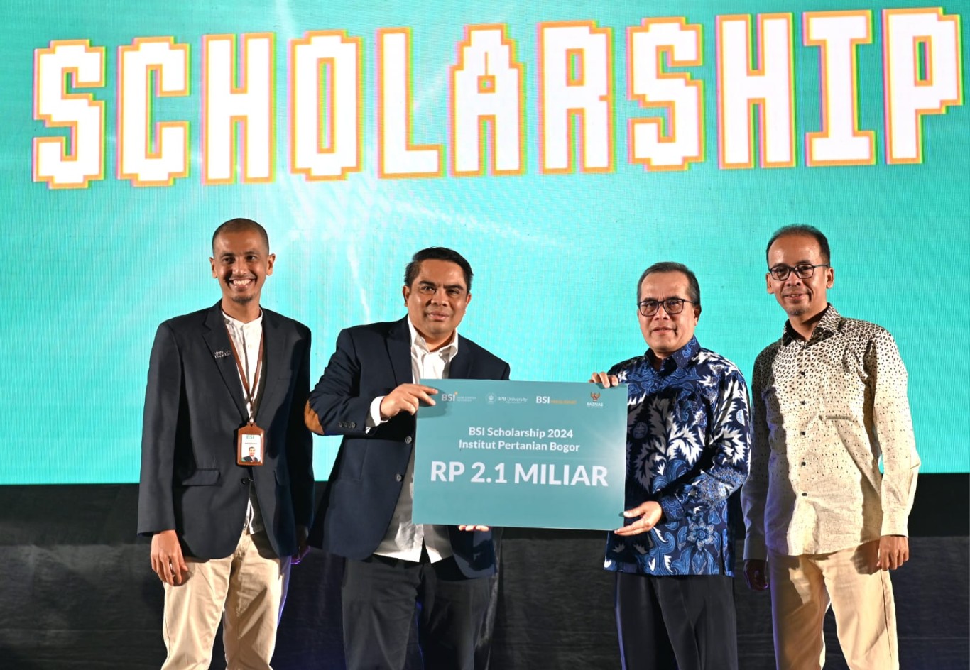 Direktur Penjualan dan Distribusi BSI Anton Sukarna (kiri kedua) menyerahkan kepada Wakil Rektor Bidang Konektivitas Global, Kerjasama dan Alumni Prof. Dr. Ir. Iskandar Zulkarnaen Siregar, M.For.Sc. (kanan kedua) simbolis bantuan program BSI Scholarship senilai Rp2,1 miliar didampingi oleh  Innovation & Empowerment Director BSI Maslahat Rusdi Mu pada gelaran BSI ROCK di Kampus IPB University Bogor, Senin (19/08).