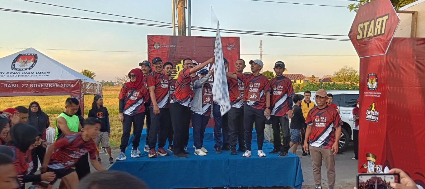 IST MENGANGKAT BENDERA--Ketua KPU Takalar mengangkat bendera star Pilkada Run KPU Takalar, Minggu 18/8