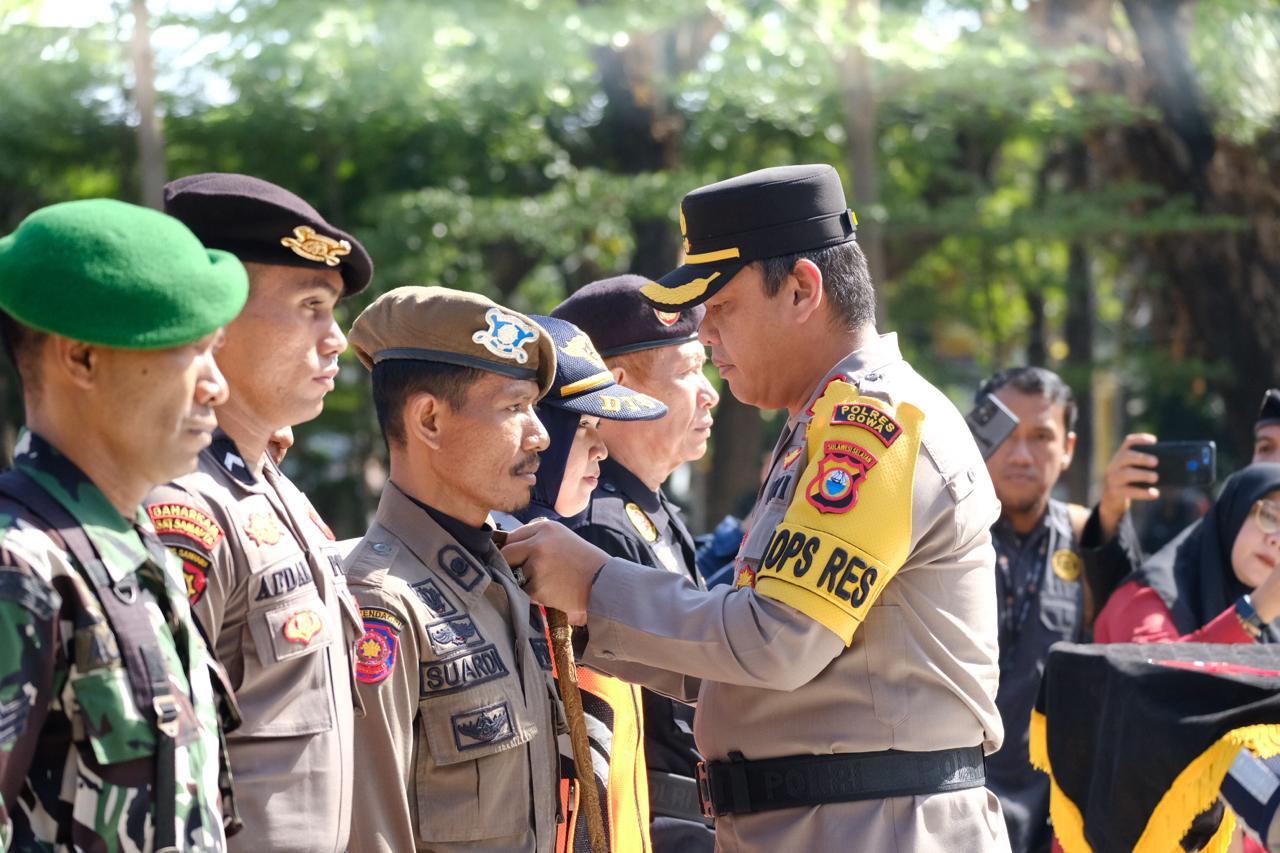 IST PASANG ATRIBUT -- Kapolres Gowa, AKBP Reonald TS Simanjuntak memasang atribut kepada petugas pengamanan Pilkada Gowa dalam apel gelar pasukan.