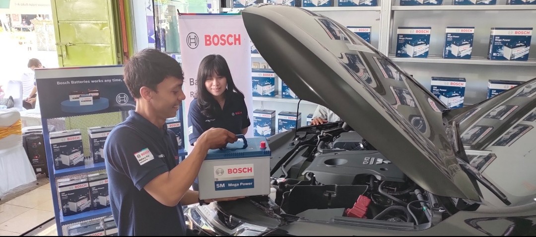 PEMASANGAN -- Channel Marketing Manager Bosch Mobility Aftermarket, Kristina Utami, melihat dari dekat pemasangan aki pada kendaraan milik konsumen setia aki Bosch.