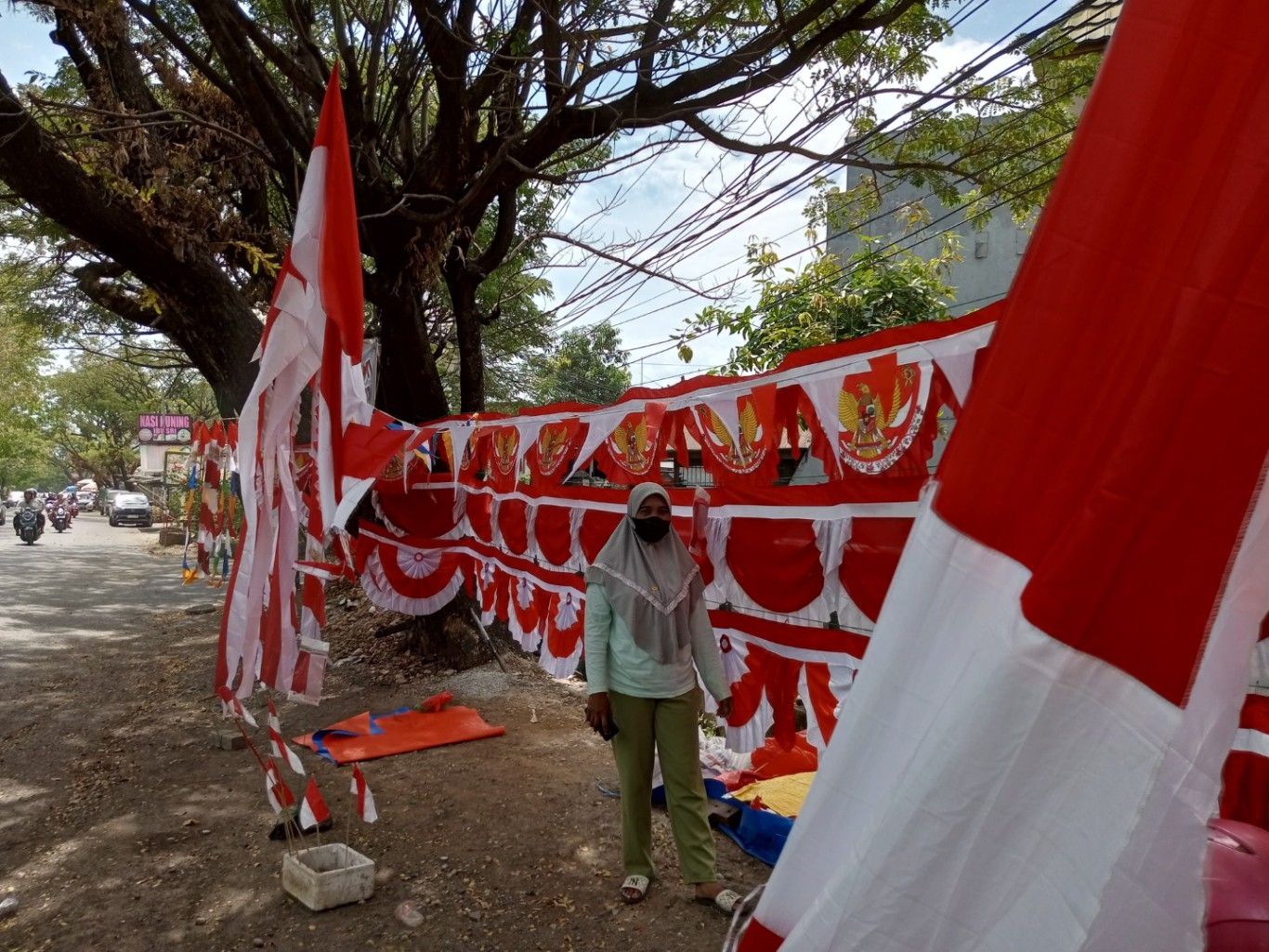 SEMANGAT--Jelang HUT Kemerdekaan RI ke 79, Hajrah begitu semangat berjualan bendera merah putih di Jalan Hertasning.Kadangkala penghasilannya mencapai Rp2 juta setiap hari.