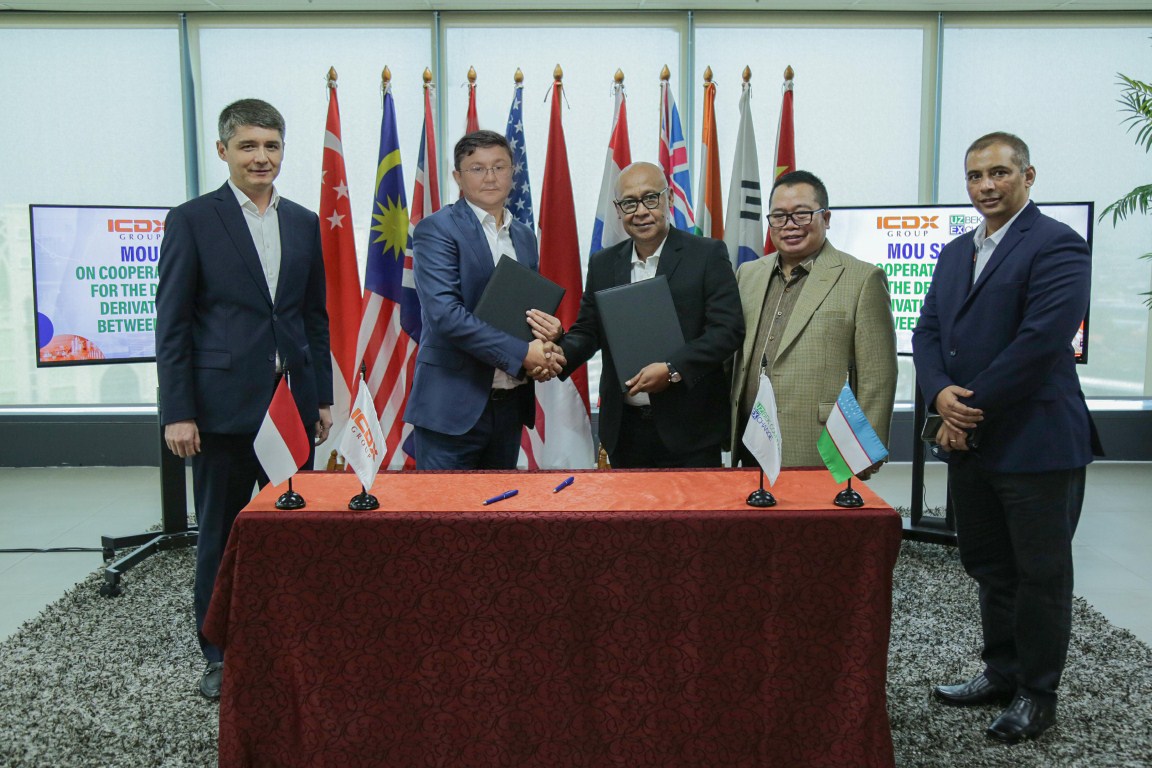 KERJA SAMA -- Direktur Utama ICDX, Fajar WibhiyadI (tengah) menyalami Ziyoviddin Badriddinov selaku Chairman of the Board Uzbek Commodity Exchange, usai melakukan penandatangan kerja sama di antara kedua belah pihak.