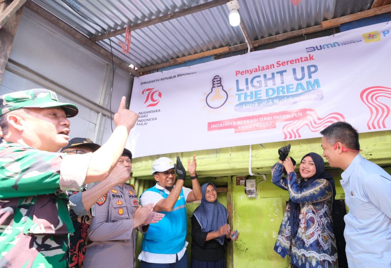 LIGHT UP THE DREAM -- Rona bahagia terpancar dari wajah Hasbia (ketiga dari kanan), salah satu penerima manfaat program Light Up The Dream saat listriknya dinyalakan oleh General Manager PLN UID Sulselrabar, Budiono (ke empat dari kiri) beserta Forkopimda Kota Makassar. 
