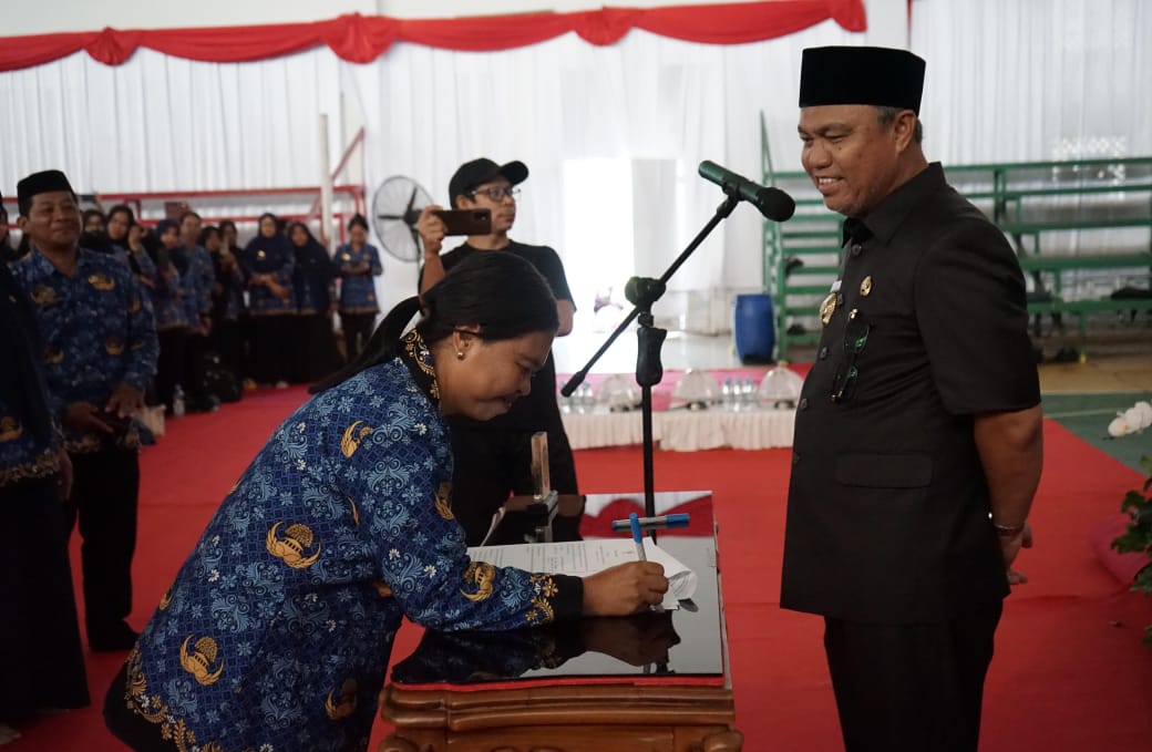 SERAHKAN SK -- Bupati Luwu Timur, H Budiman menyerahkan secara simbolis SK PPPK dirangkai pengambilan sumpah janji jabatan fungsional PPPK Formasi tahun 2019, 2021 dan 2022 lingkup Pemkab Luwu Timur di Gedung Olahraga, Malili baru-baru ini.  