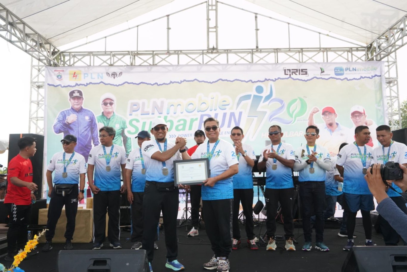REC -- General Manager PLN UID Sulselrabar, Budiono (kiri) menyerahkan menyerahkan secara simbolis REC kepada Sekprov Sulbar, Muhammad Idris dalam ajang PLN Mobile Sulbar Run 2024.

