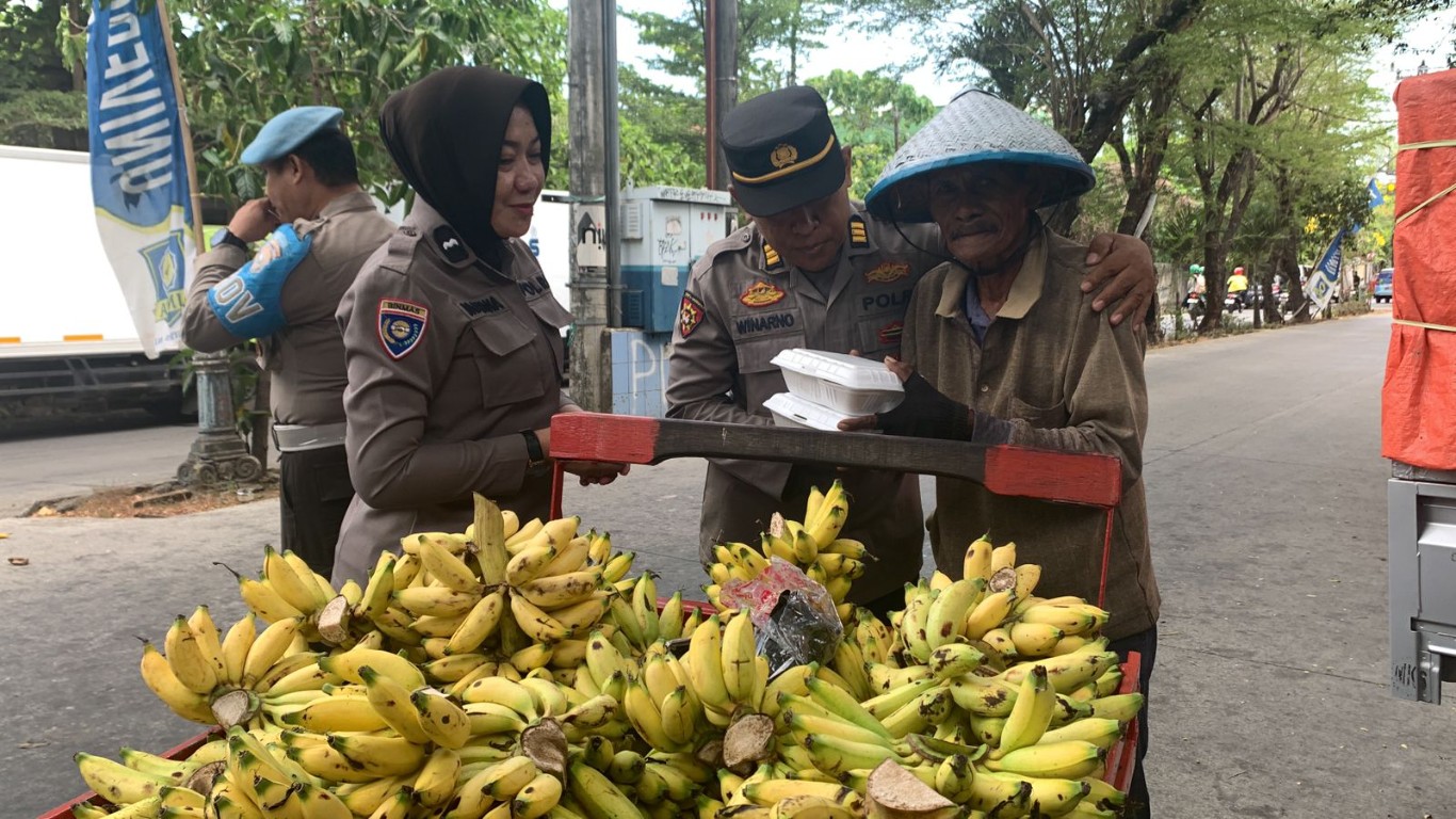 BAGIKAN MAKANAN -- Waka Polsek Panakkukang, AKP Winarno bersama personelnya, membagikan makanan kepada sejumlah warga.
