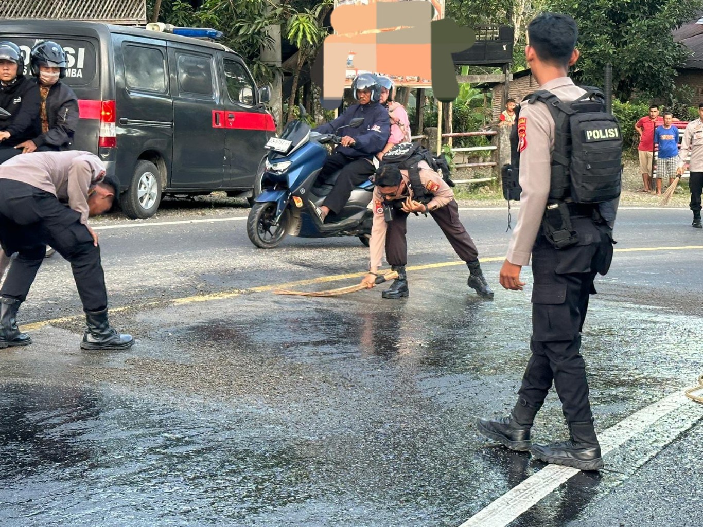 AKSI SOSIAL -- Personel Sat Samapta Polres Bulukumba melakukan aksi sosial di Jalan Poros Bulukumba-Sinjai. Sejumlah polisi berseragam lengkap secara sigap membersihkan tumpahan material yang ada di badan jalan.