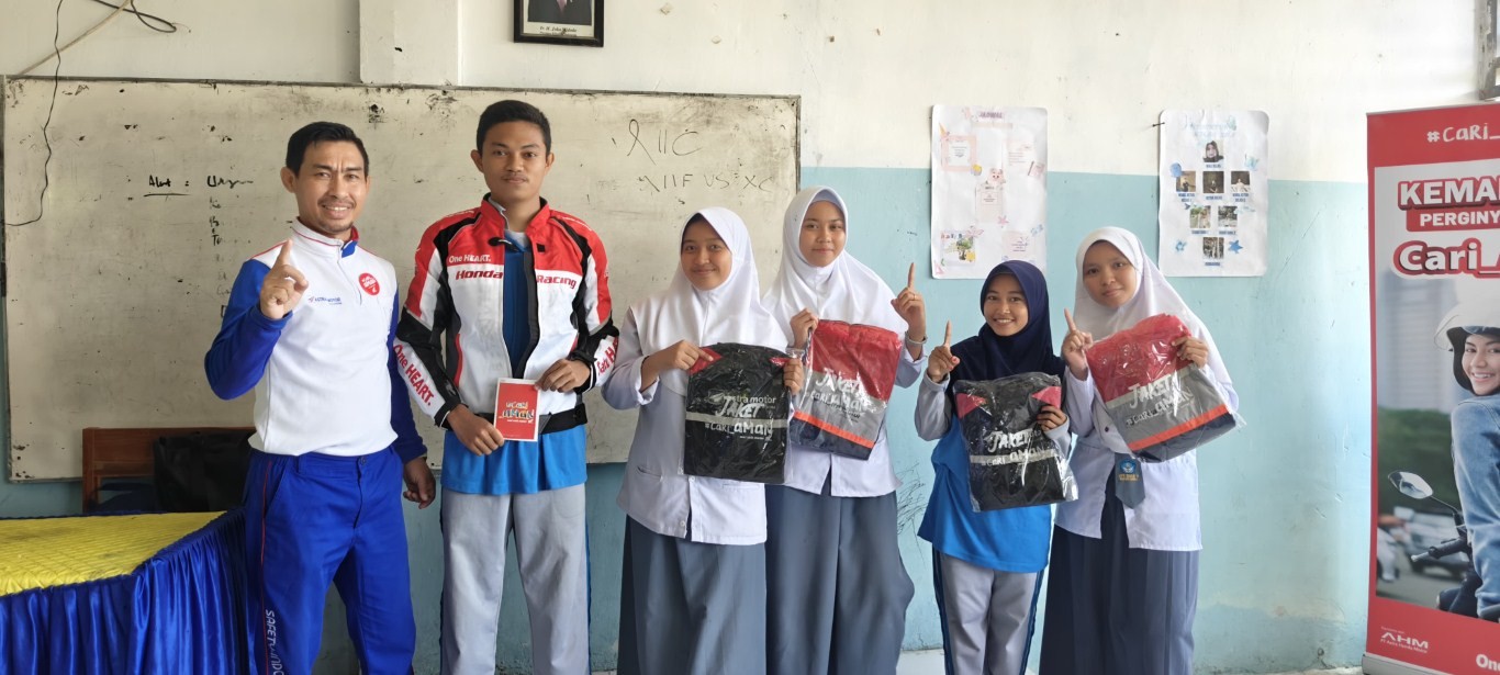SAFETY RIDING -- Instruktur Safety Riding Astra Motor Sulawesi Selatan, Wanny Dewa (kiri) foto bersama sejumlah siswa SMA usai menyerahkan hadiah di sela melakukan edukasi safety riding.
