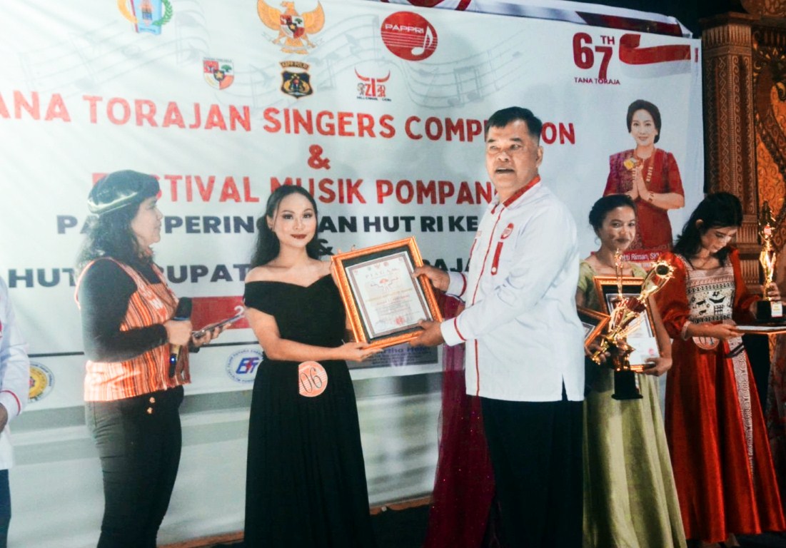 HADIAH -- Tim juara festival musik pompang saat penerimaan hadiah di pelataran Pasar Seni Makale. Festival digelar selama empat hari (28-31/8) lalu.