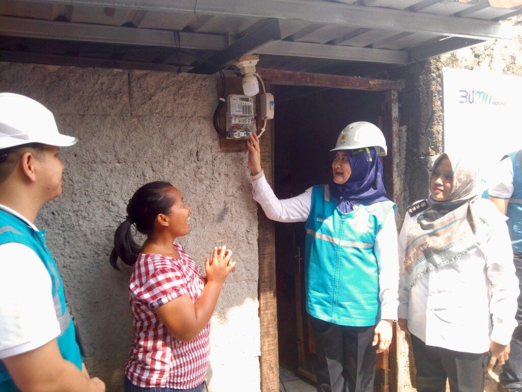 PENYALAAN -- General Manager PLN UID Jawa Barat, Susiana Mutia (kedua dari kanan) melakukan penyalaan listrik secara simbolis di rumah Ridayanti (kedua dari kiri), salah satu penerima bantuan program Light Up The Dream di Bekasi pada (23/10). 
