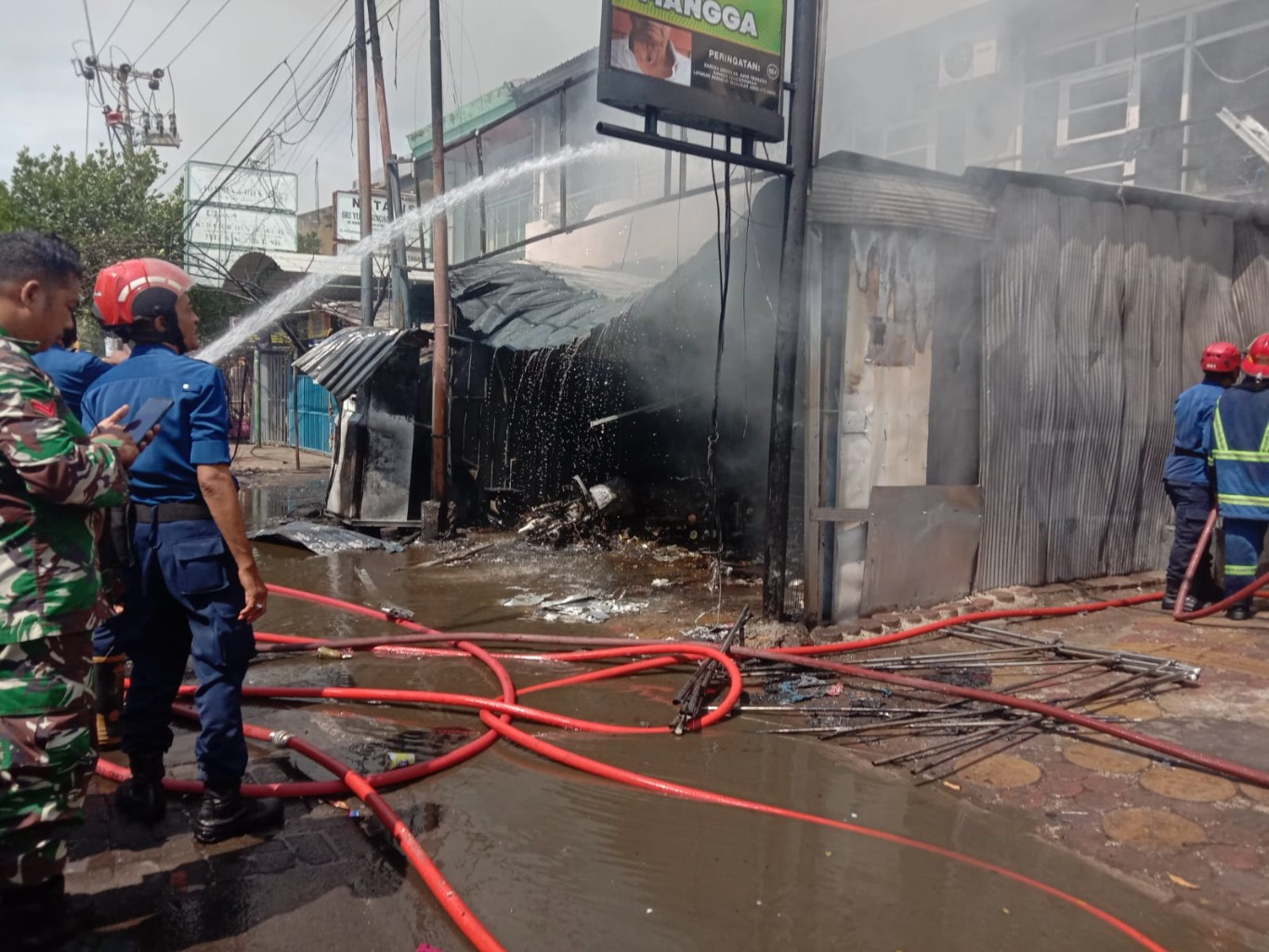 PERTAMINI -- Petugas pemadam kebakaran berjuang habis-habisan untuk memadamkan api yang membakar satu unit rumah akibat Pertamini yang korslet dan meledak lalu terbakar.