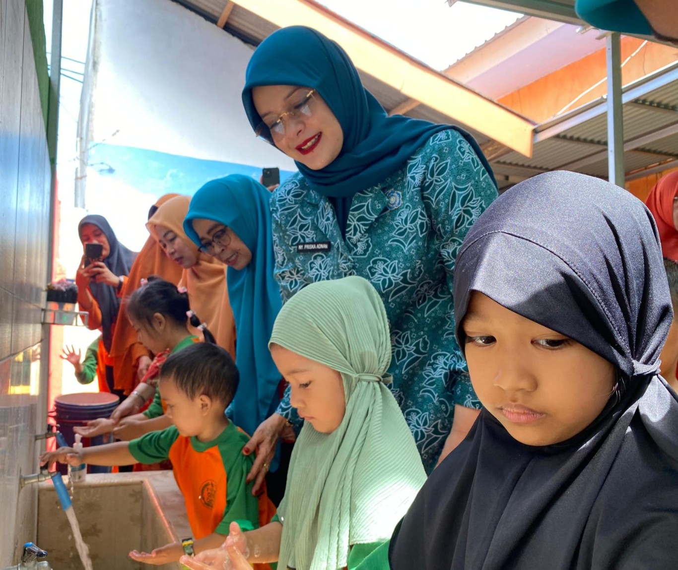 IST
CUCI TANGAN -- Ketua TP PKK Gowa, Priska Paramita Adnan dan Ketua DWP Gowa, Suryanti Andy Azis menyaksikan aktivitas para murid TK Pertiwi mencuci tangan pakai sabun. 
