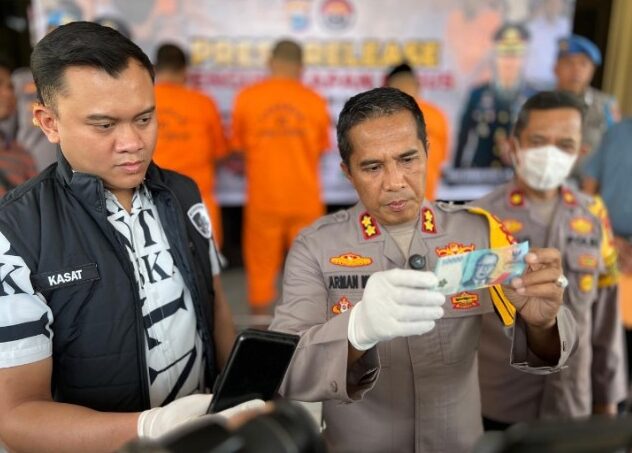 UANG PALSU -- Kapolres Parepare AKBP Arman Muis saat memegang barang bukti uang palsu pecahan Rp 50 ribu yang telah diderahkan ketiga pelaku di Kota Parepare.
