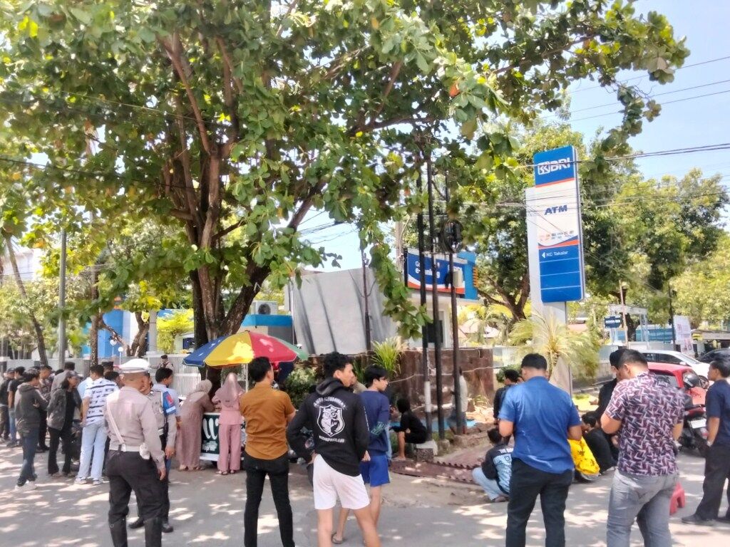 UNJUK RASA -- Puluhan pemuda dan mahasiswa ketlka menggelar aksi unjuk rasa di depan kantor BRI Cabang Takalar.