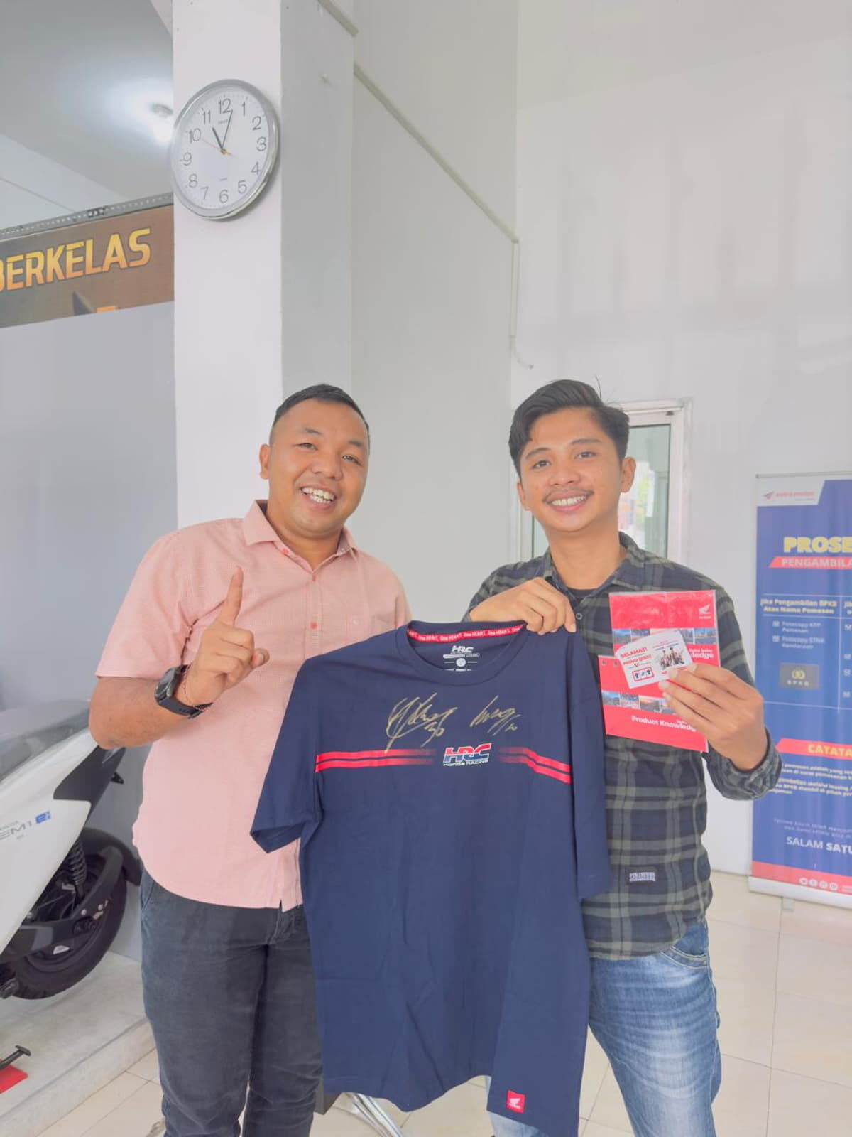 PEMENANG -- Jedil I Bayan dari Mamuju, Sulawesi Barat (kanan) menerima apparel resmi Honda yang ditandatangani pembalap Repsol, JoanMir/Luca Marini oleh PDCA Analyst Astra Motor Sulawesi Selatan, Hans Andreas Mikhael, di Makassar.
