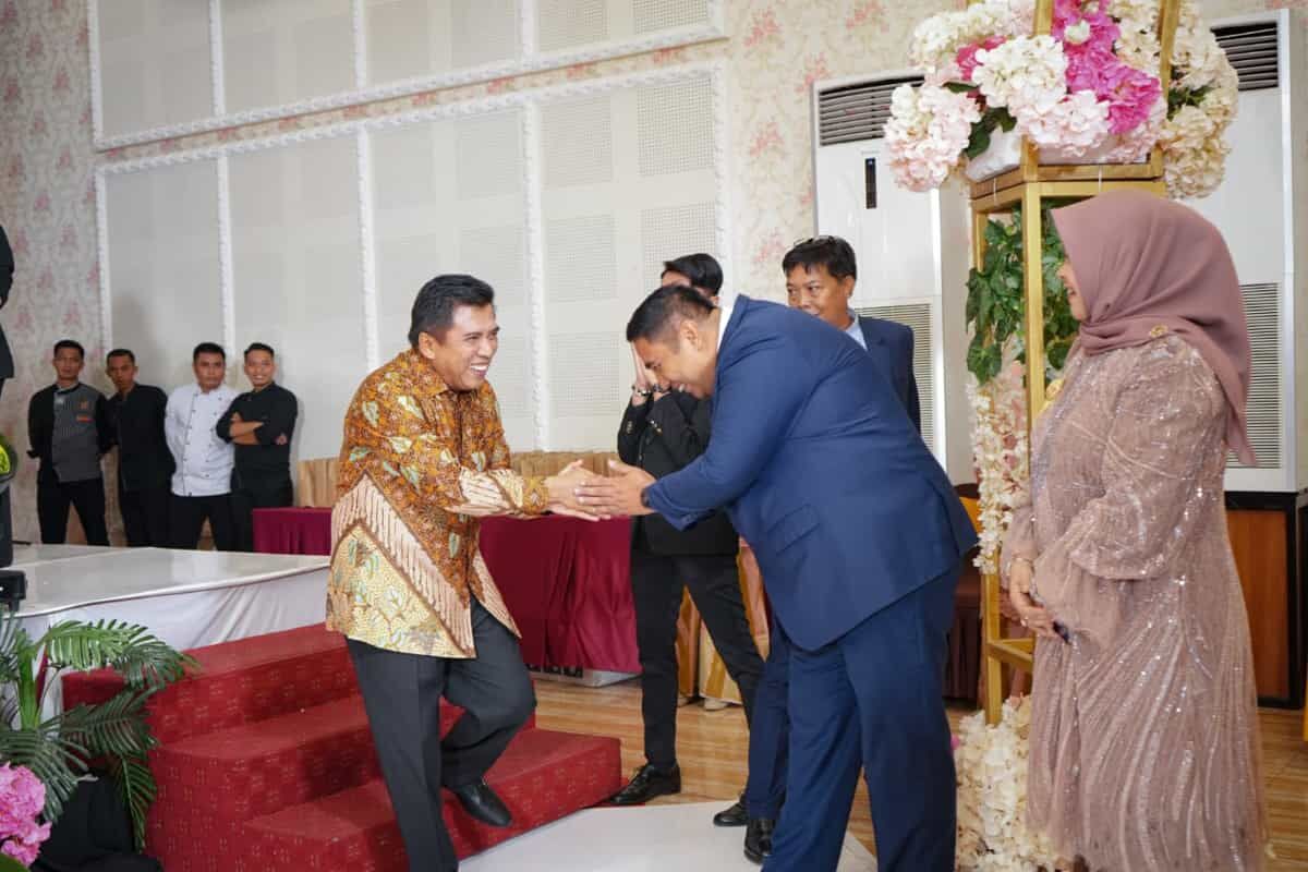 BERTEMU -- Bupati Maros dua periode, Hatta Rahman dan calon Bupati Maros, Chaidir Syam bersalaman dan saling melempar senyuman saat bertemu di suatu pesta pernikahan.
