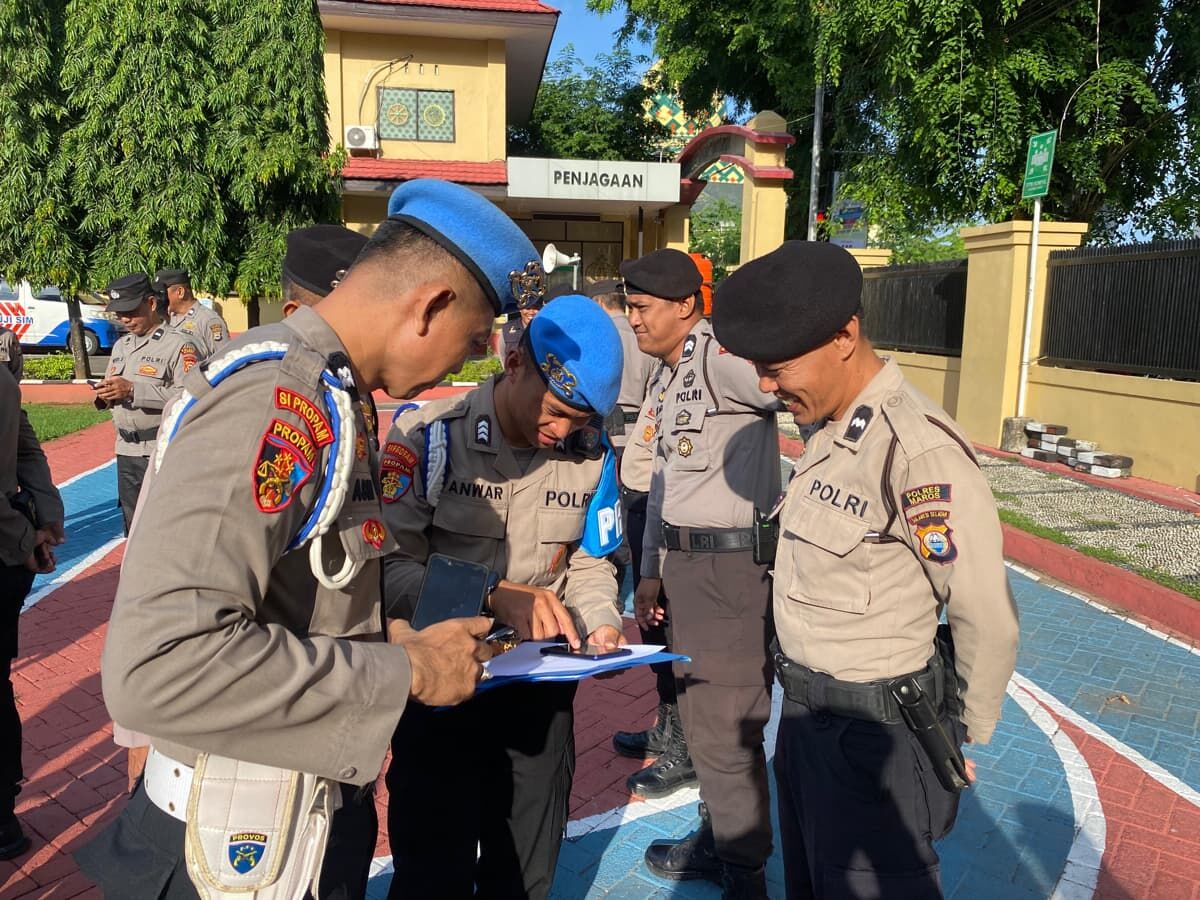 PERIKSA -- Kasi Propam Polres Maros, AKP Mansyur M, saat memeriksa gawai milik anggotanya. 
