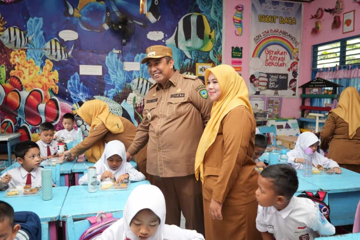 TINJAU -- Bupati Maros, Chaidir Syam, saat meninjau dan memantau langsung penyaluran makan siang gratis, kemarin
