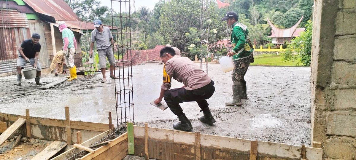 GOTONG ROYONG -- Bhabinkamtibmas Polsek Mengkendek, Aiptu Amos Manda mengadakan kegiatan gotong royong melakukan pengecoran rumah warga binaannya di Kelurahan Lemo, Kecamatan Mengkendek, Sabtu (22/2).  
