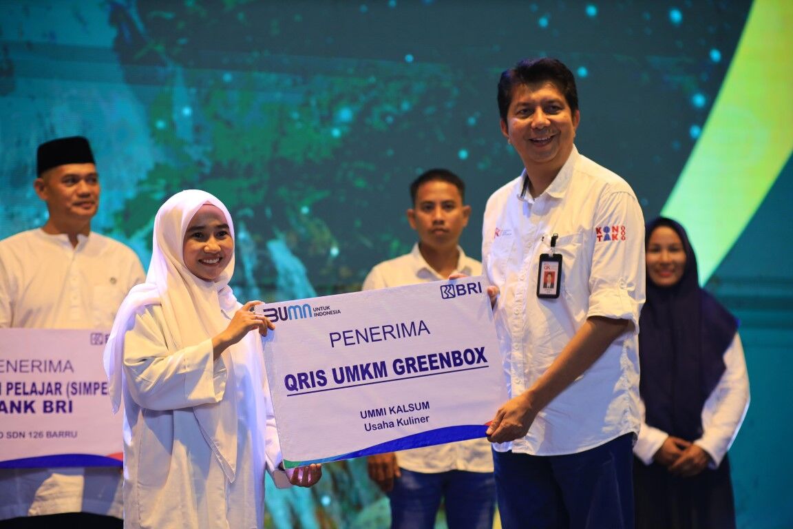 QRIS UMKM -- Kepala OJK Provinsi Sulawesi Selatan dan Sulawesi Barat, Darwisman, menyerahkan QRIS UMKM Greenbox kepada Ummi Qalsum selaku owner.
