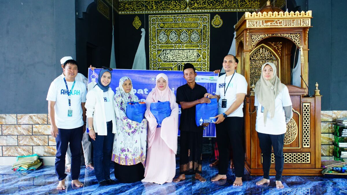 BERBAGI -- Kepala Departement Bisnis Support Kanwil Makassar, Iwan Darmawan, menyerahkan bingkisan kepada warga kurang mampu.
