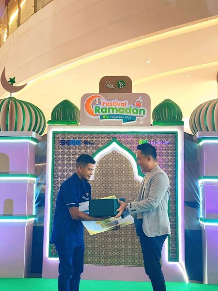 GRAND PRIZE -- Deputy Bisnis Pegadaian Area Kendari, Riolan Manik menyerahkan hadiah grand prize berupa emas batangan 24 karat 123 gram, Hasimuddin, nasabah dari Pegadaian Cabang Wua Wua Area Kendari, pada Acara Festival Ramadan di The Park Mall Kendari.
