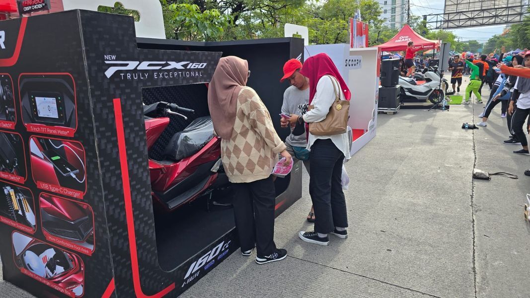 SEDOT PERHATIAN -- Sejumlah pengunjung CFD mendapatkan penjelasan seputar beragam produk sepeda motor Honda yang ditampilkan dalam Box Eksklusif.
