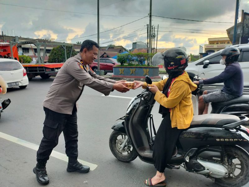 TAKJIL -- Personel Polres sedang membagikan takjil kepada pengendara sepeda motor.
