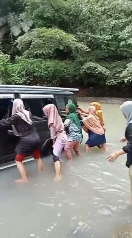 DORONG MOBIL -- Para emak-emak berupaya mendorong sebuah mobil minibus agar bisa melintasi Sungai  Datae wilayah Dusun Mattirobulu Desa Bulue Kecamatan Marioriawa Kabupaten Soppeng, Senin (8/4).  
