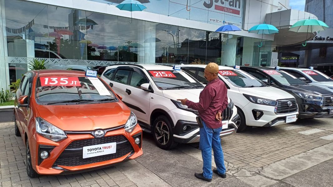 TOYOTA TRUST -- Salah seorang pengunjung Kalla Toyota Alauddin melihat dari dekat deretan mobil bekas Toyota yang dijual di depan Pooling Toyota Trust Alauddin.
